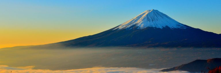 black and white mountain over yellow white and blue sky